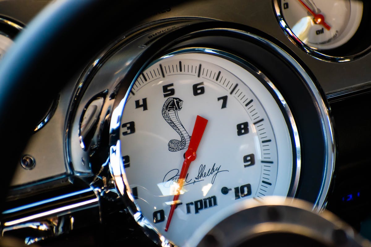 A close-up of a classic Shelby-style dashboard with the cobra emblem.